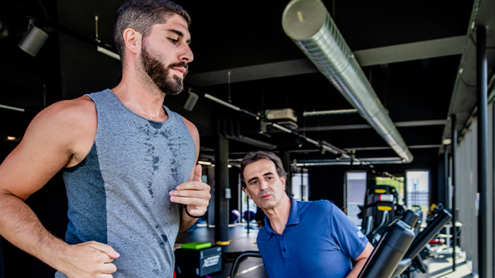 Athletic man runs on a treadmill under the observation of a sports physiotherapist at the Swiss Medical Network